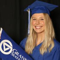 GradFest attendee holding up the gvsu flag by herself